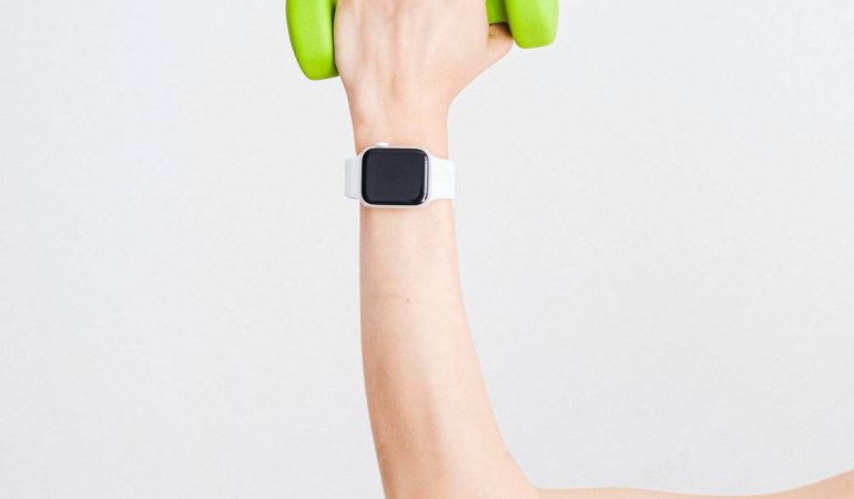 person-wearing-white-apple-watch-while-holding-green-4482936